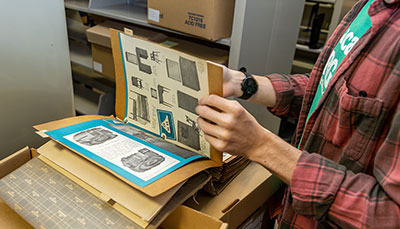 Person showing a furniture sales catalog from the library archives.