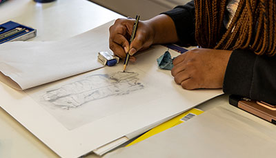Student drawing in a sketch book.