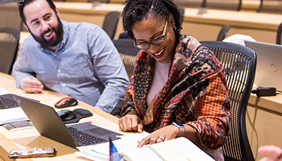 Students working together at a desk in a classroom.
