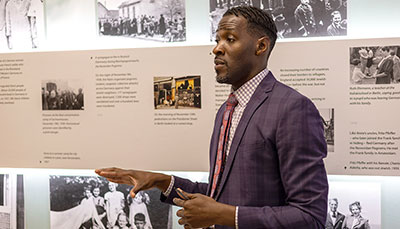 Educator standing in front of an information panel giving a lecture. 
